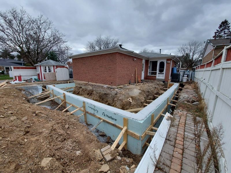 Insulated concrete form foundation walls beside a brick house