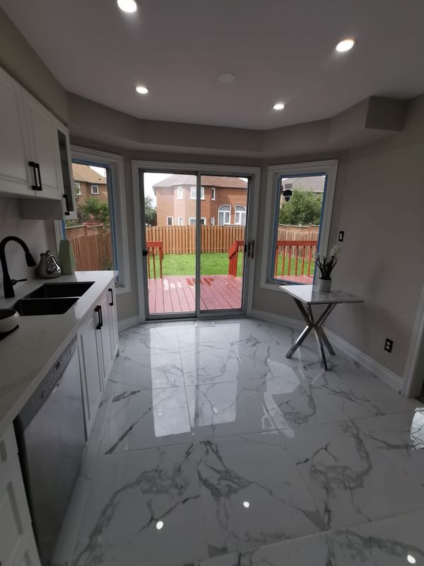 Breakfast area with large marble-look porcelain tile and a sliding patio door