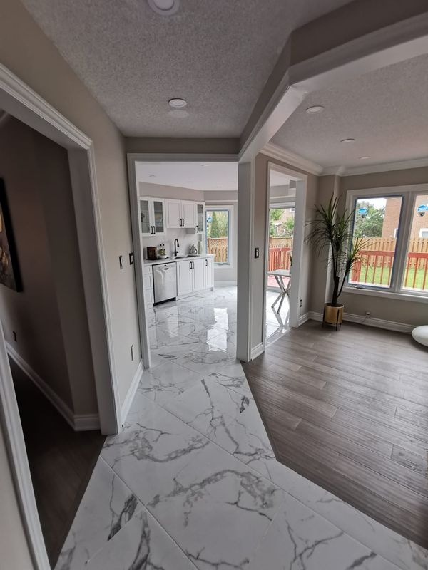Hallway with marble-look tile set on the diagonal next to grey wood-look flooring